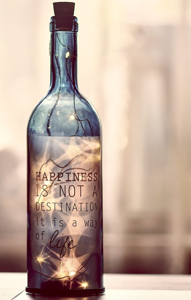 Bouteille en verre avec citation écrite dessus et de la lumière a l'intérieur