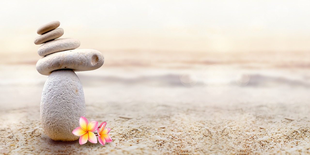 Photo zen représentant le sable avec une pyramide de galets